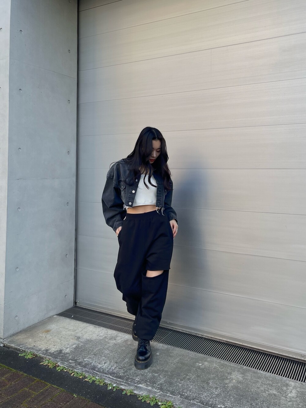 ブラック系のデニムジャケット、ブラック系のスウェットパンツを着用したレディースの冬コーディネートの2枚目の写真