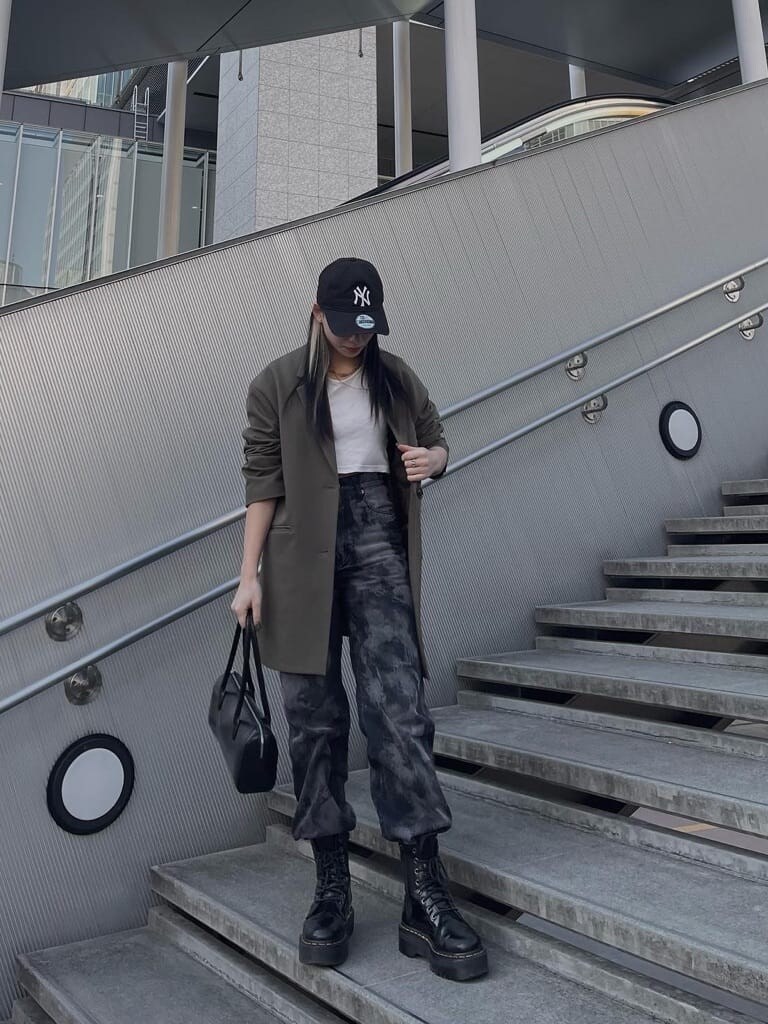 ブラック系のボストンバッグ、ブラック系のデニムパンツを着用したレディースの春コーディネートの3枚目の写真