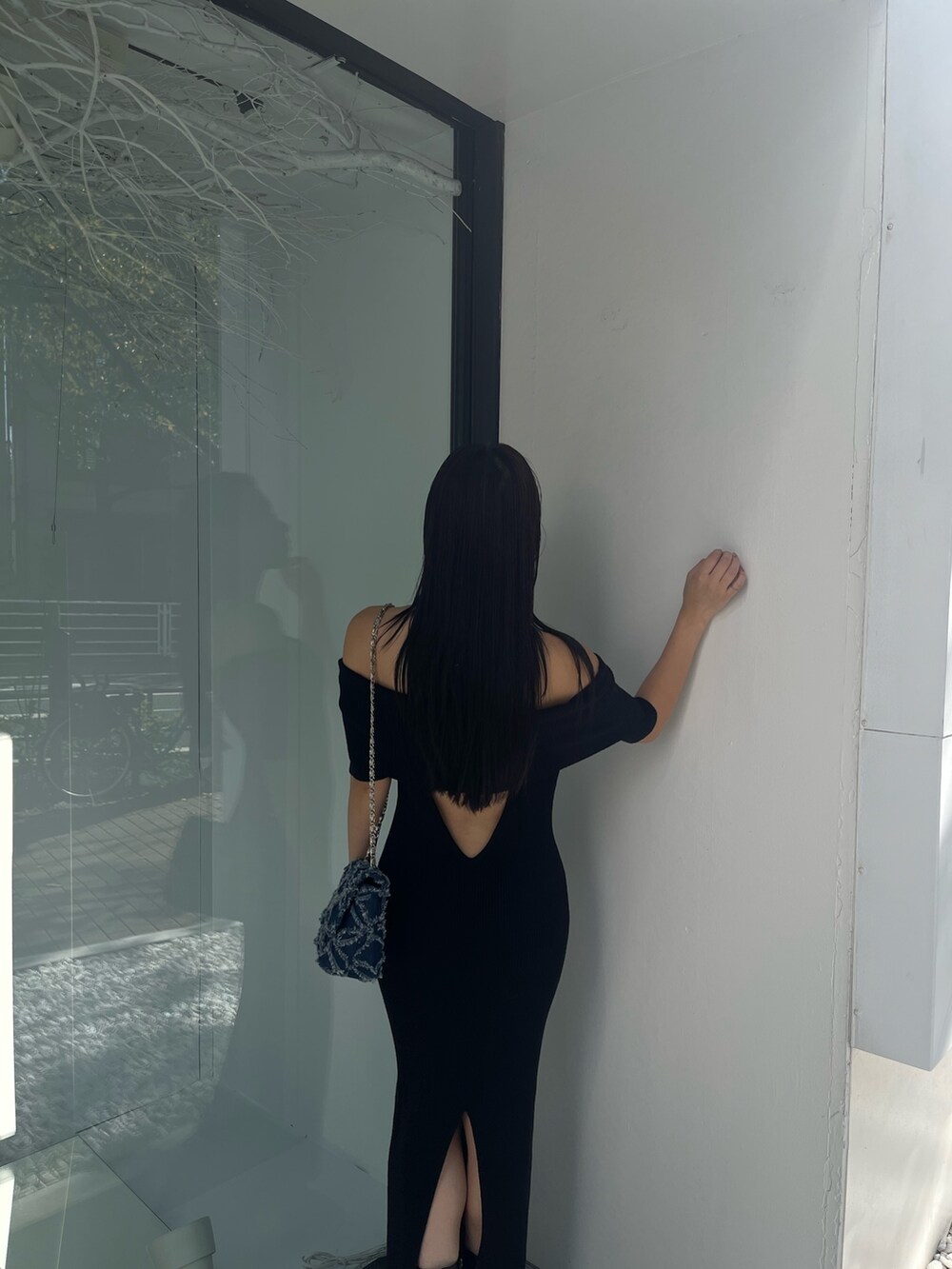 ブラック系のワンピース、ブルー系のショルダーバッグを着用したレディースの秋コーディネートの4枚目の写真