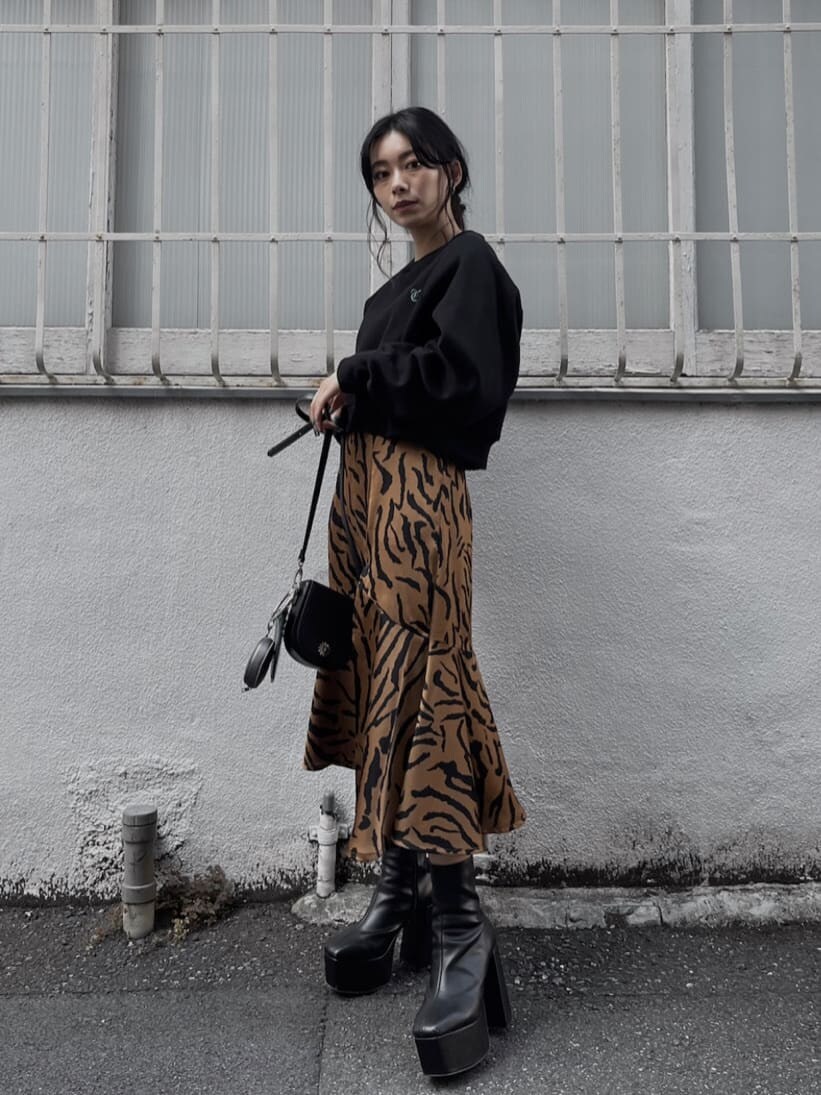 ブラック系のブーツ、ブラック系のショルダーバッグ、その他のスカートを着用したレディースの秋コーディネートの5枚目の写真