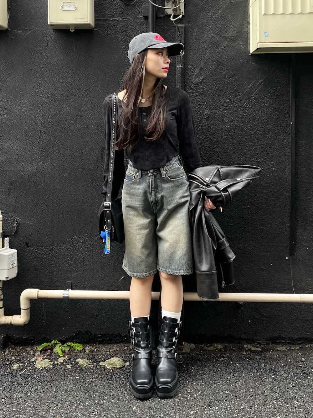 ブラック系のTシャツ/カットソー、ブルー系のデニムパンツ、ブラック系のブーツを着用したレディースの春コーディネートの2枚目の写真