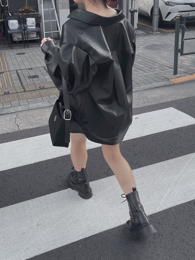 ブラック系のスカート、ブラック系のショルダーバッグ、ブラック系のブーツを着用したレディースの夏コーディネートの2枚目の写真