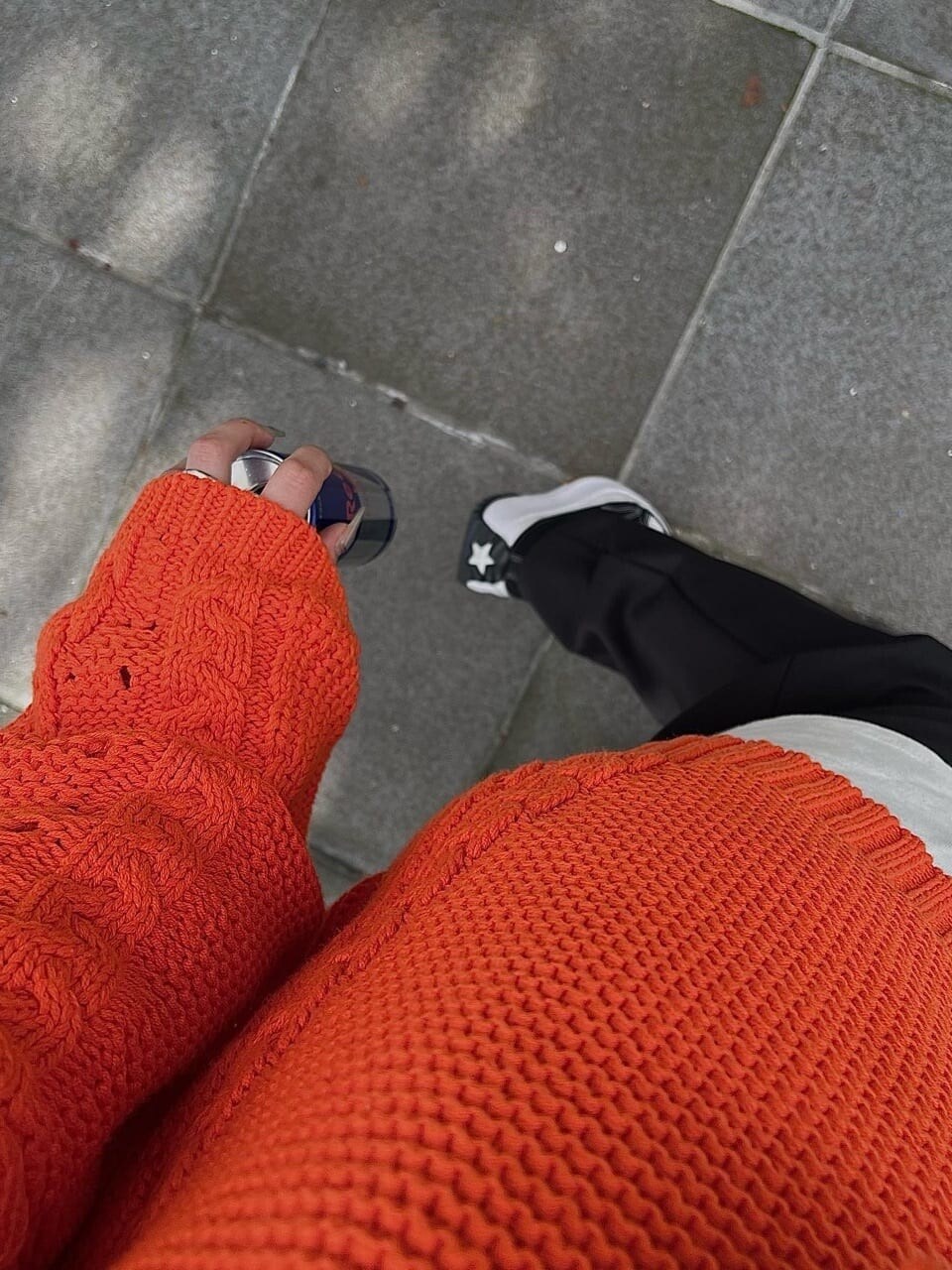 オレンジ系のニット/セーター、ブラック系のスラックスを着用したレディースの秋コーディネートの6枚目の写真