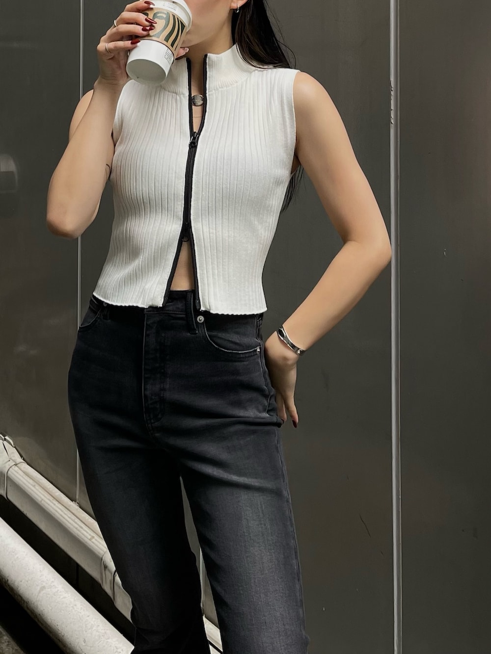 ホワイト系のタンクトップ、ブラック系のデニムパンツを着用したレディースの春コーディネートの4枚目の写真