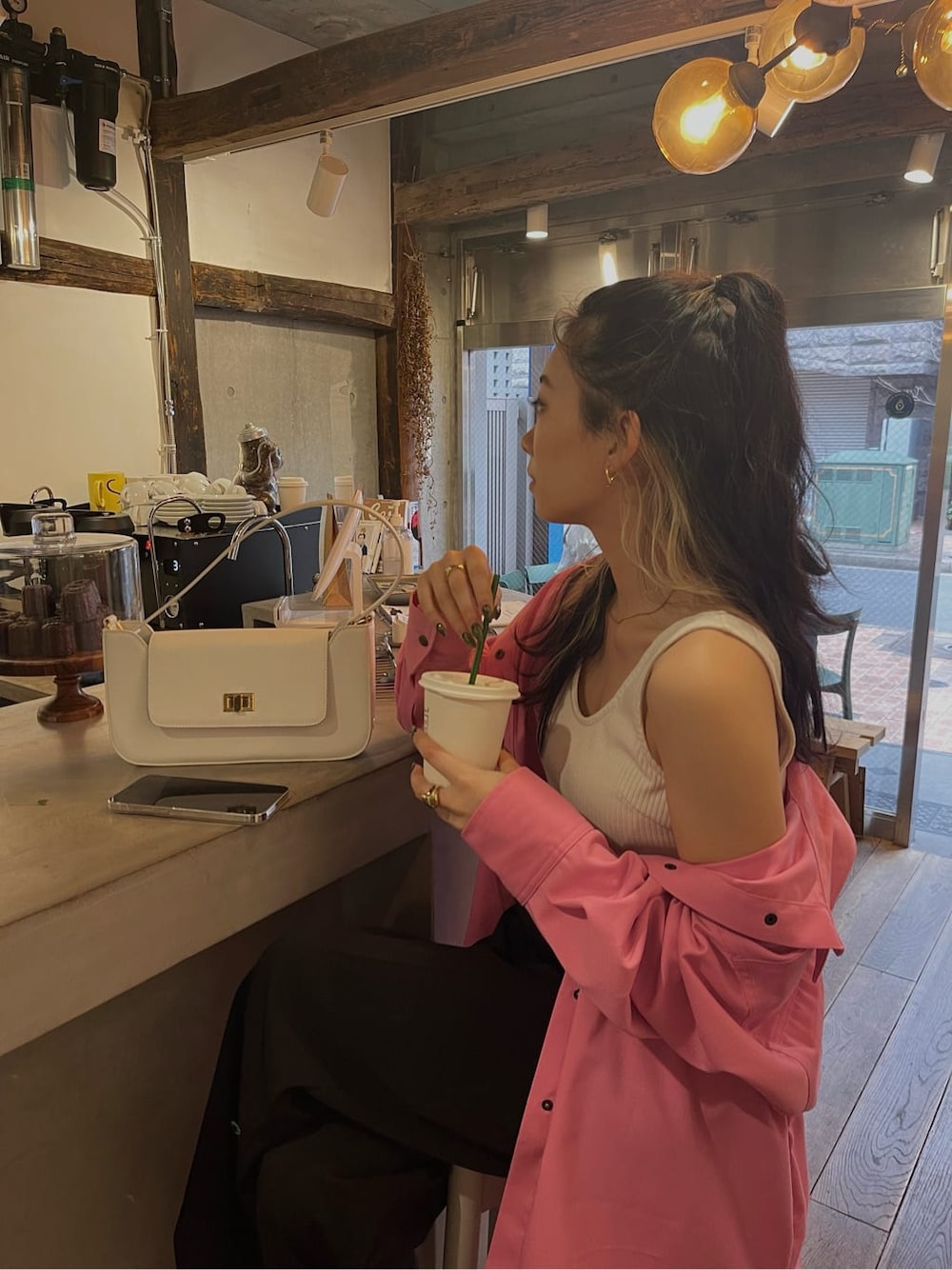 ホワイト系のショルダーバッグ、ピンク系のシャツ/ブラウス、ブラック系のスラックスを着用したレディースの春コーディネートの2枚目の写真