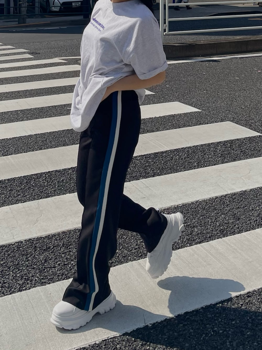 グレー系のTシャツ/カットソー、ブラック系のスラックス、ホワイト系のスニーカーを着用したレディースの春コーディネートの3枚目の写真