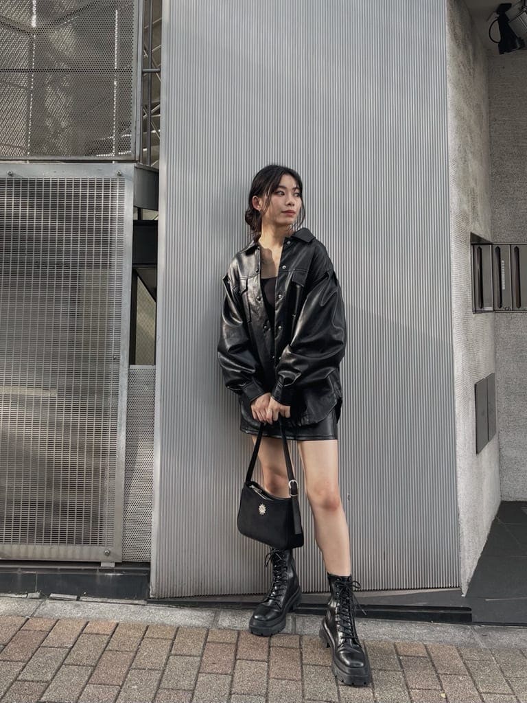 ブラック系のスカート、ブラック系のショルダーバッグ、ブラック系のブーツを着用したレディースの夏コーディネートの3枚目の写真