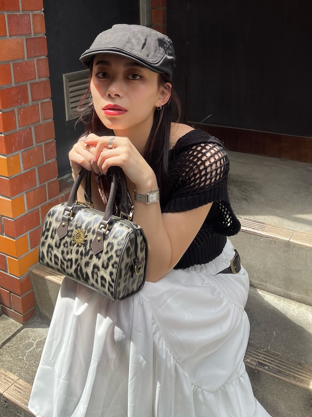 ブラック系のニット/セーター、その他のショルダーバッグ、ブラック系のブーツを着用したレディースの春コーディネートの4枚目の写真