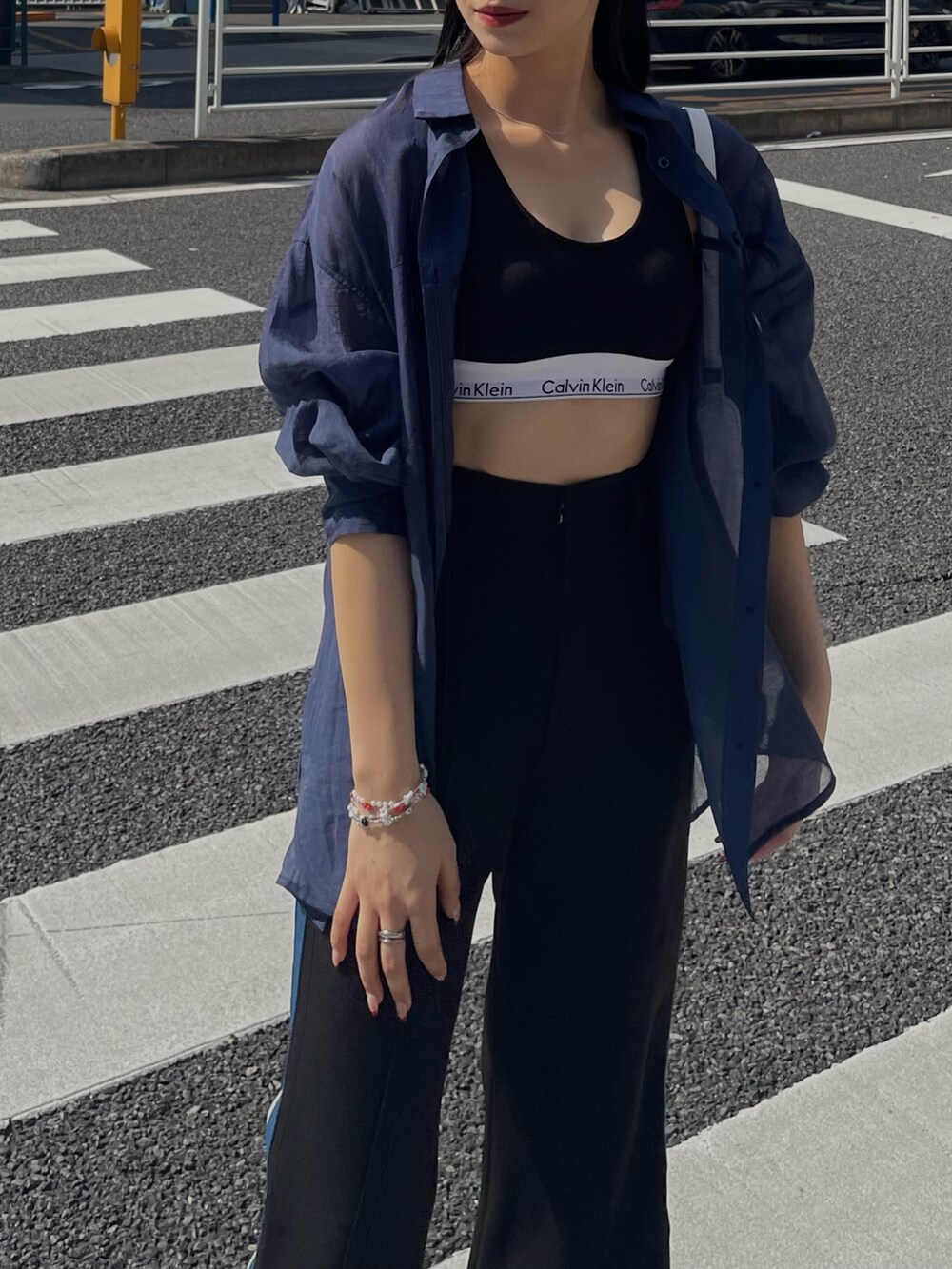 ブルー系のシャツ/ブラウス、ブラック系のスラックスを着用したレディースの春コーディネートの4枚目の写真