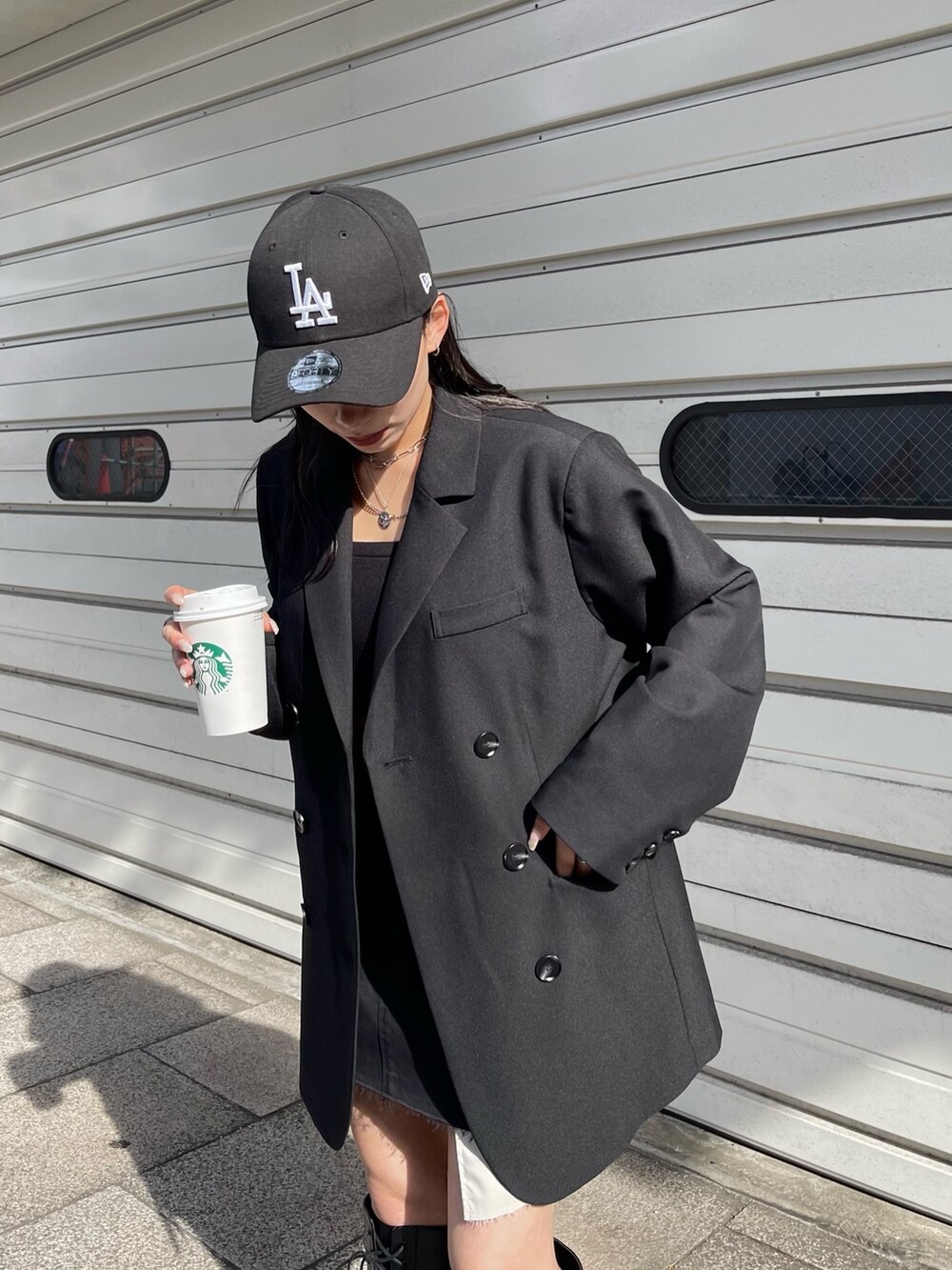 ブラック系のテーラードジャケット、ブラック系のスカート、ブラック系のブーツを着用したレディースの冬コーディネートの3枚目の写真