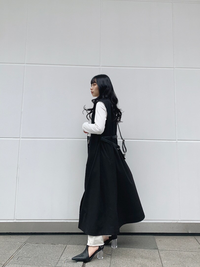 ホワイト系のTシャツ/カットソー、ブラック系のトレンチコート、ブラック系のパンプスを着用したレディースの春コーディネートの5枚目の写真