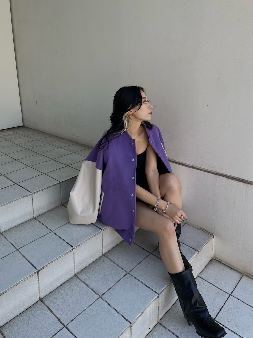 パープル系のスタジャン、ブラック系のブーツを着用したレディースの冬コーディネートの2枚目の写真