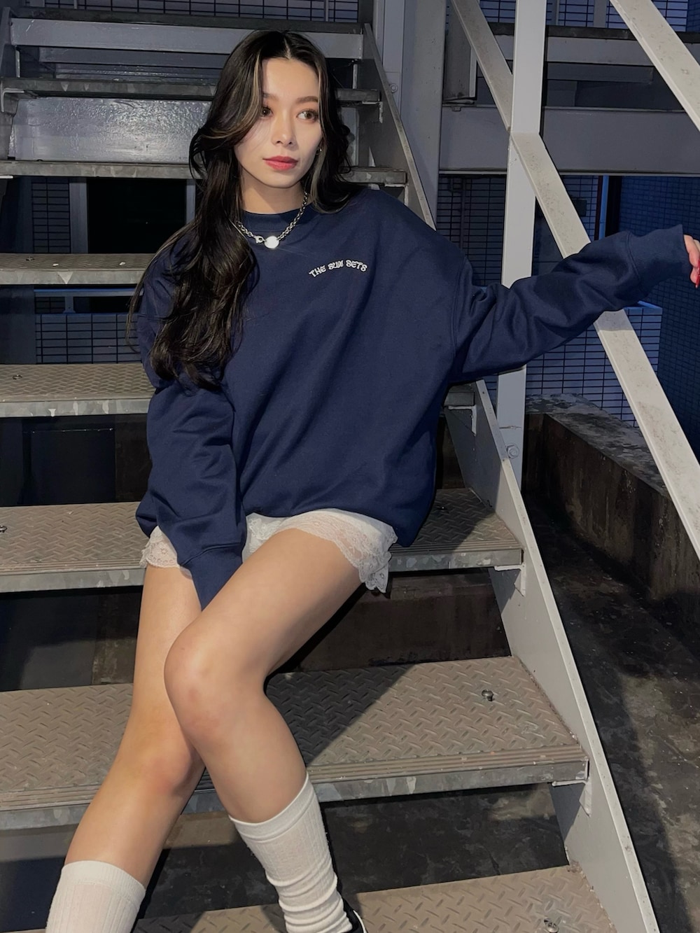 ブルー系のスウェット、ブラック系のスニーカーを着用したレディースの冬コーディネートの2枚目の写真