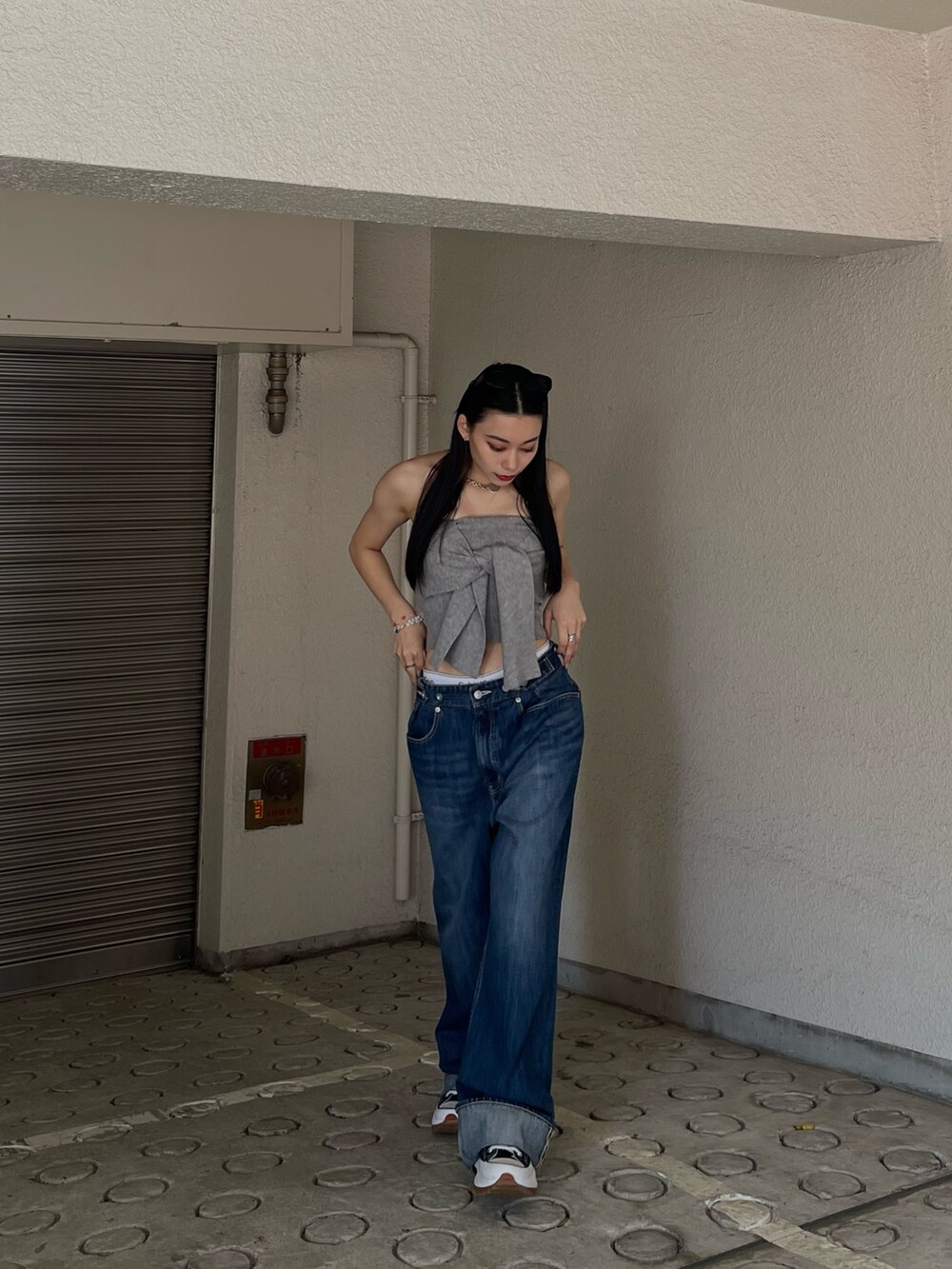 グレー系のチューブトップ、ブルー系のデニムパンツを着用したレディースの春コーディネートの7枚目の写真