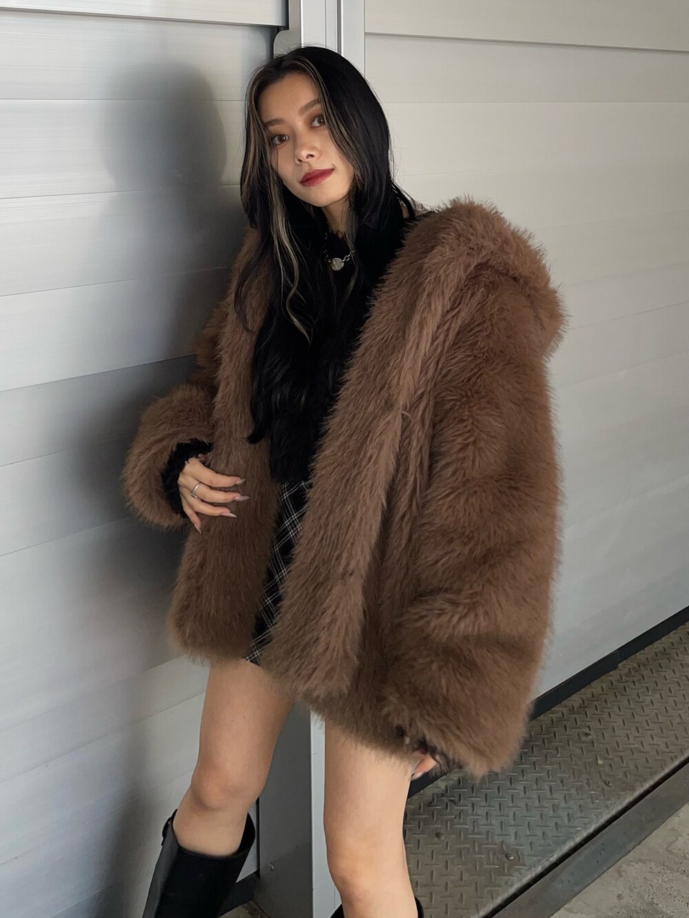 ブラウン系のブルゾン、ブラック系のニット/セーター、ブラック系のスカートを着用したレディースの秋コーディネートの3枚目の写真