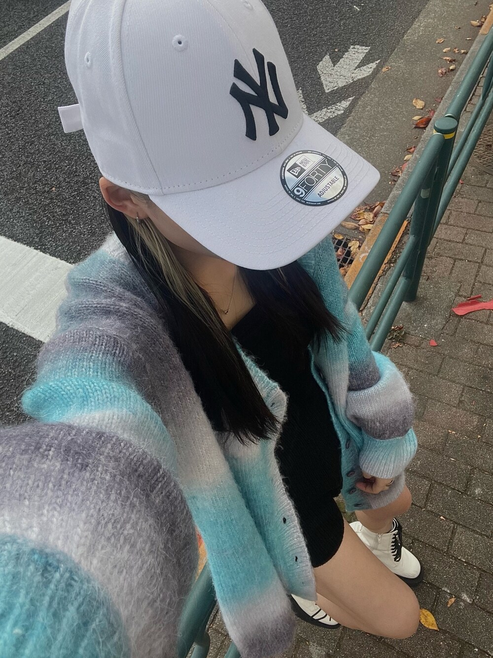 ブルー系のカーディガン/ボレロ、ホワイト系のブーツを着用したレディースの秋コーディネートの4枚目の写真