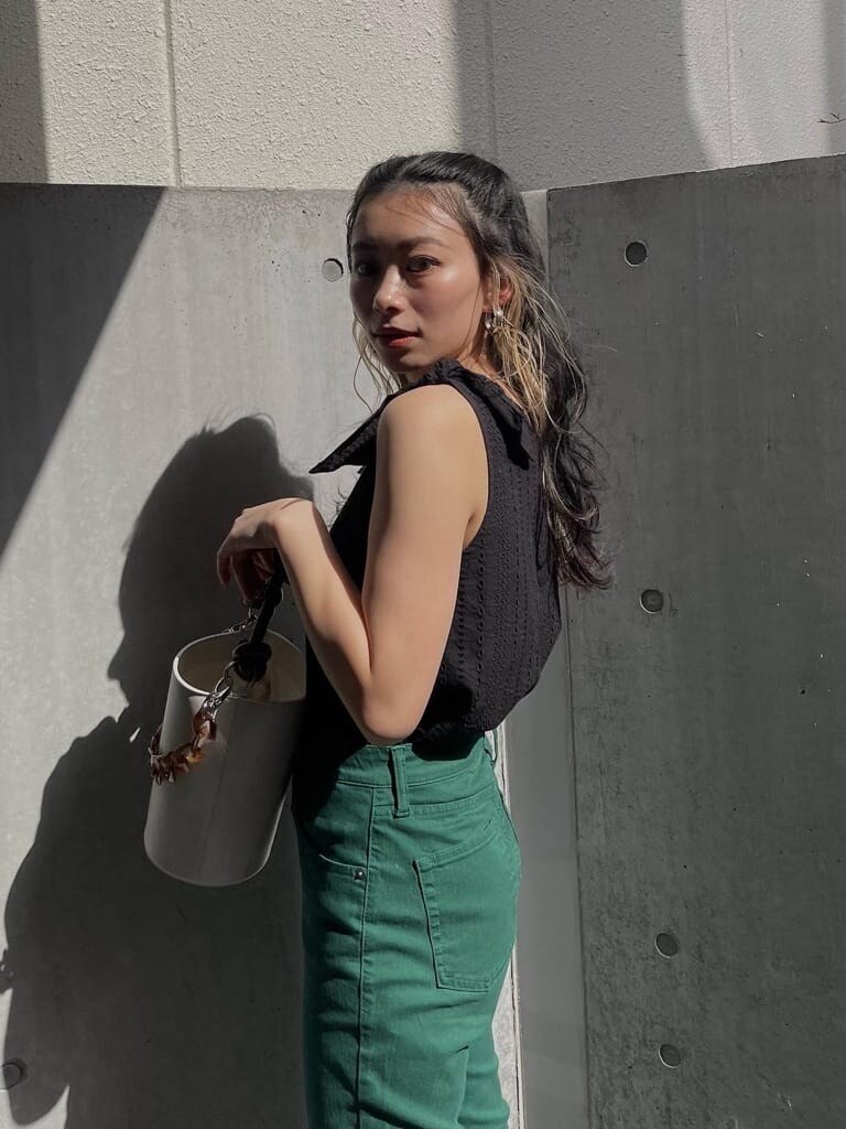 ブラック系のシャツ/ブラウス、ホワイト系のショルダーバッグ、グリーン系のデニムパンツを着用したレディースの春コーディネートの2枚目の写真