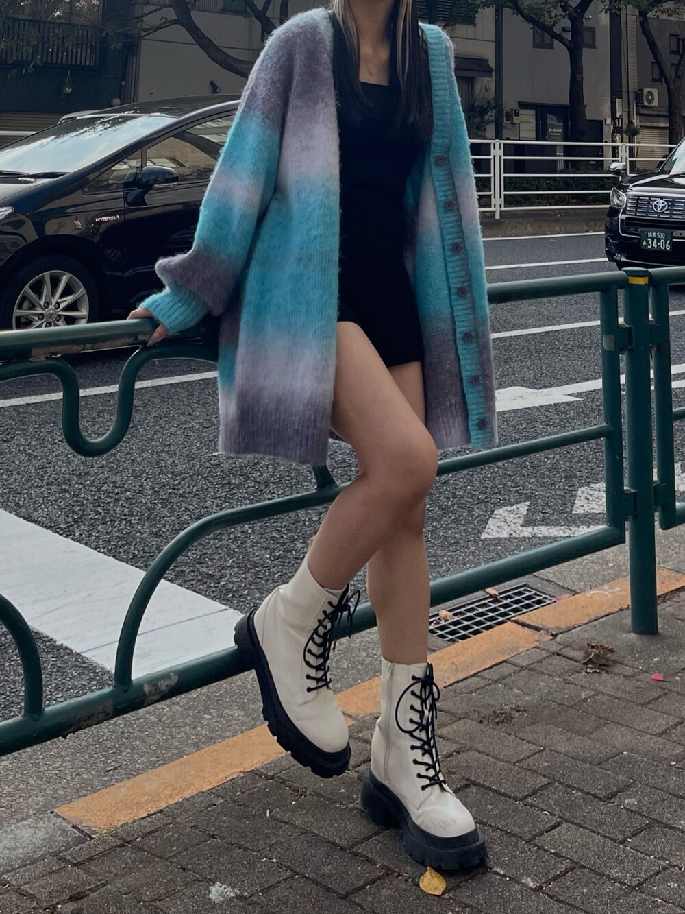 ブルー系のカーディガン/ボレロ、ホワイト系のブーツを着用したレディースの秋コーディネートの3枚目の写真