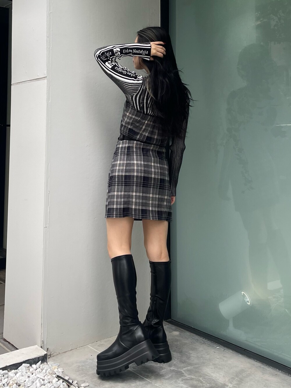 ブラック系のニット/セーター、ブラック系のワンピース、ブラック系のブーツを着用したレディースの秋コーディネートの2枚目の写真