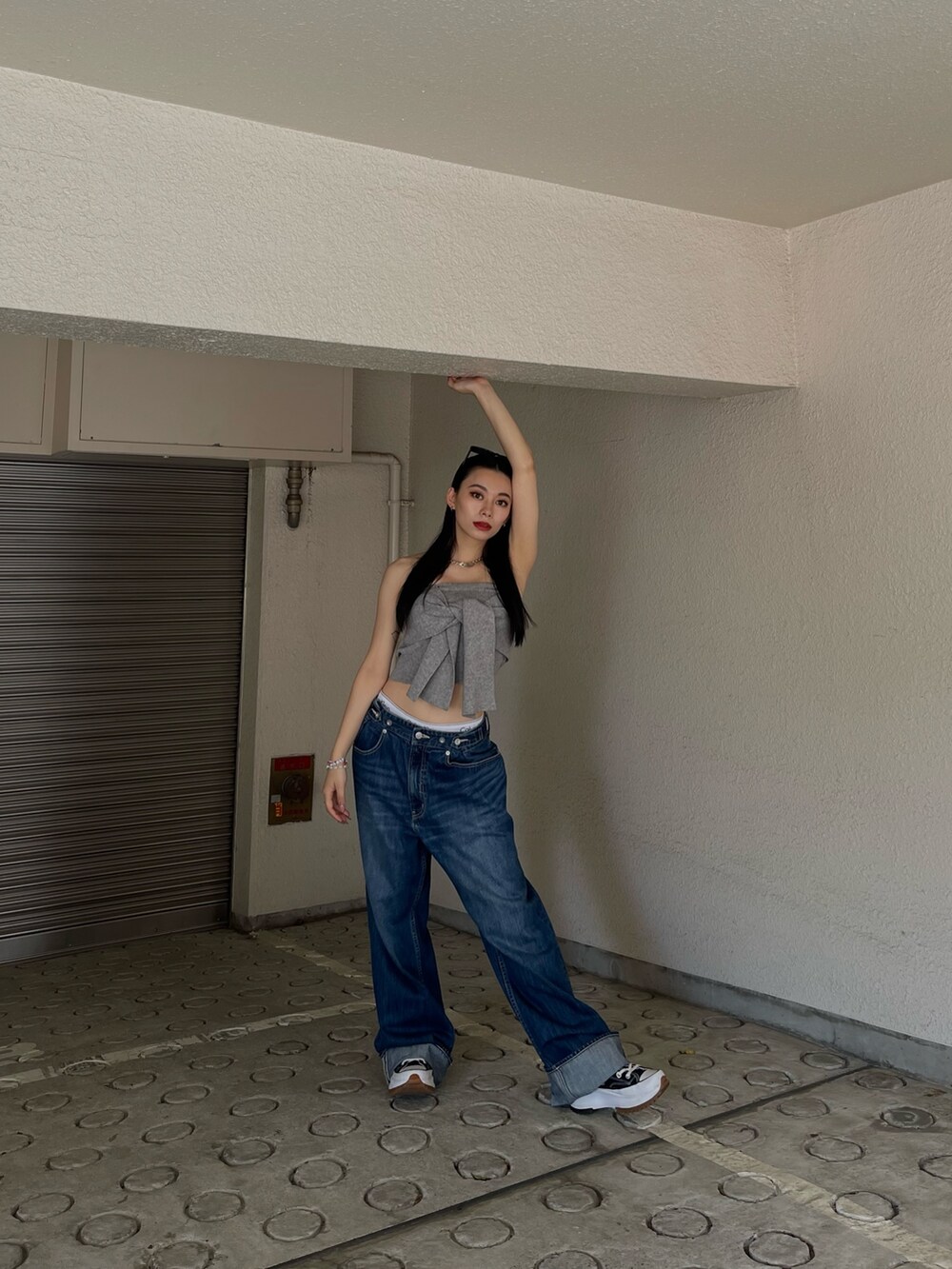 グレー系のチューブトップ、ブルー系のデニムパンツを着用したレディースの春コーディネートの2枚目の写真