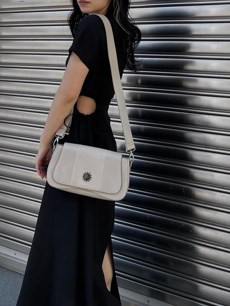 ブラック系のワンピース、ホワイト系のショルダーバッグを着用したレディースの春コーディネートの2枚目の写真