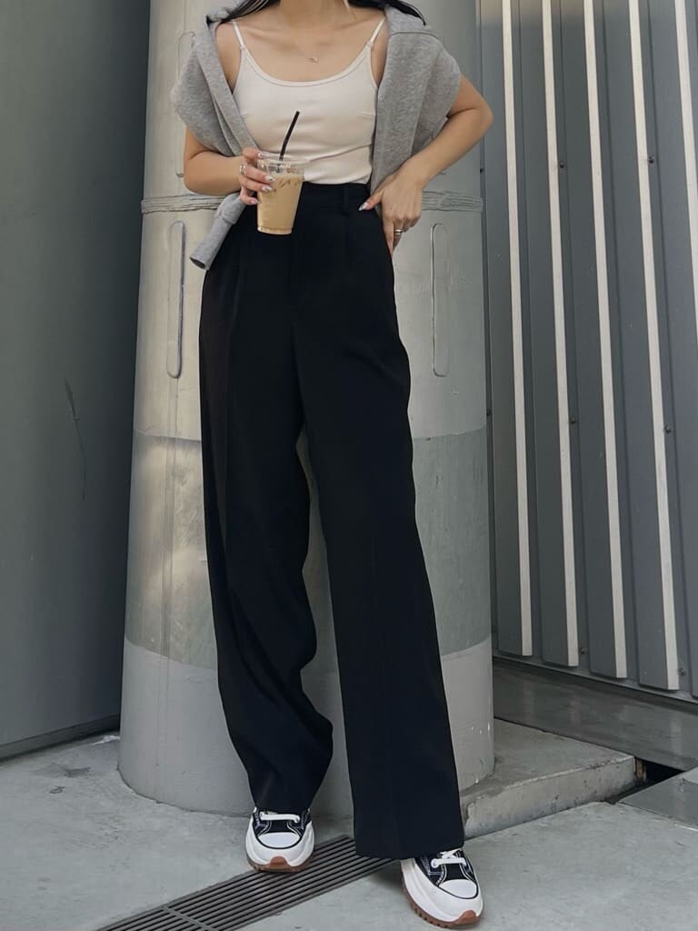 ブラック系のスラックス、グレー系のカーディガン/ボレロ、ホワイト系のキャミソールを着用したレディースの春コーディネートの2枚目の写真