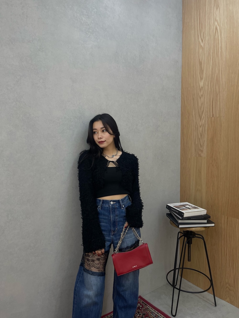 ブラック系のニット/セーター、ブルー系のデニムパンツを着用したレディースの春コーディネートの3枚目の写真