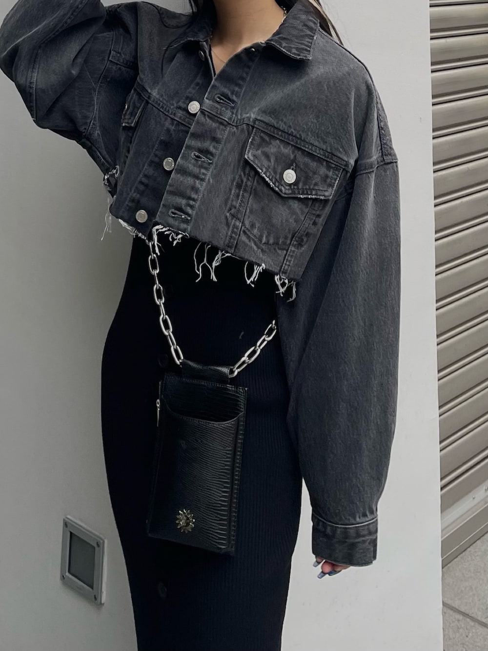 ブラック系のデニムジャケット、ブラック系のショルダーバッグ、ブラック系のワンピースを着用したレディースの冬コーディネートの2枚目の写真
