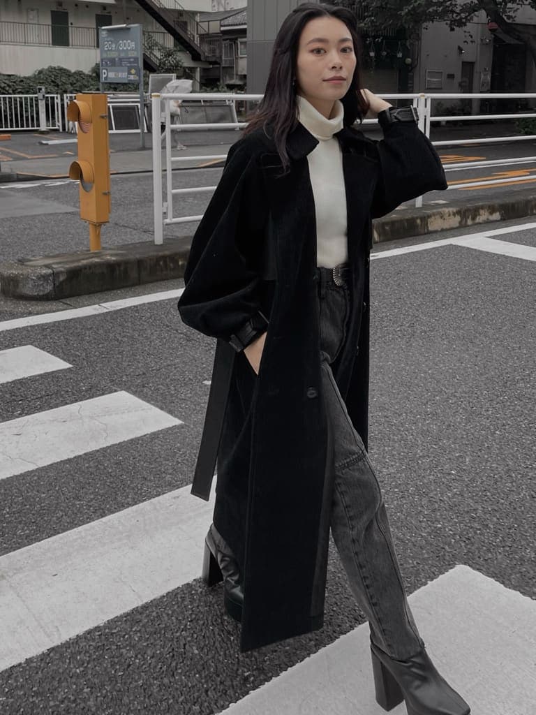 ブラック系のブーツ、ブラック系のデニムパンツ、ブラック系のトレンチコートを着用したレディースの秋コーディネートの2枚目の写真