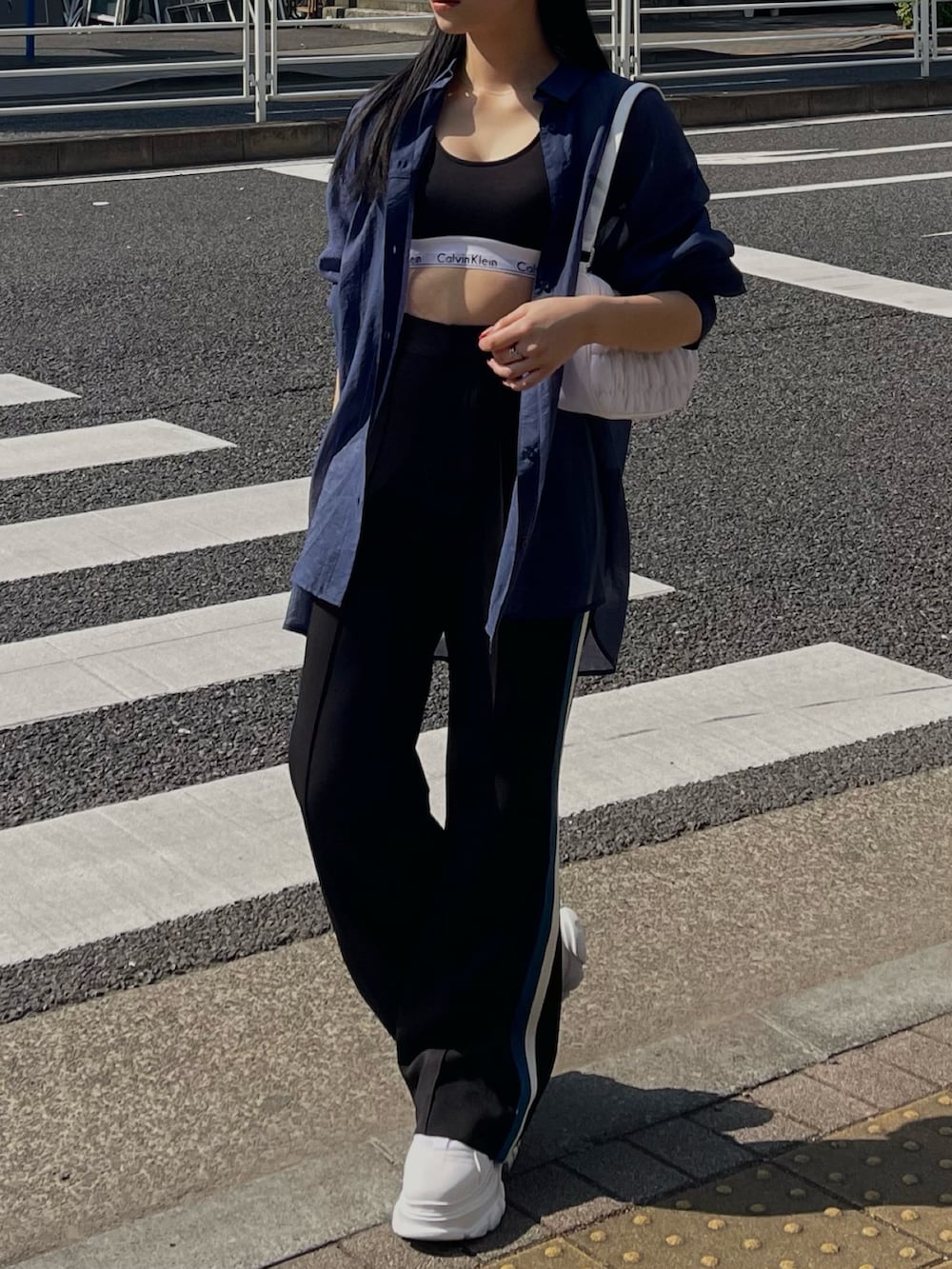 ブルー系のシャツ/ブラウス、ブラック系のスラックスを着用したレディースの春コーディネートの2枚目の写真