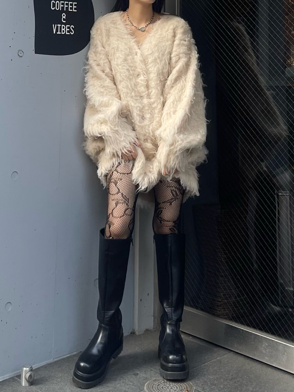 ブラック系のブーツ、ホワイト系のカーディガン/ボレロを着用したレディースの秋コーディネートの3枚目の写真