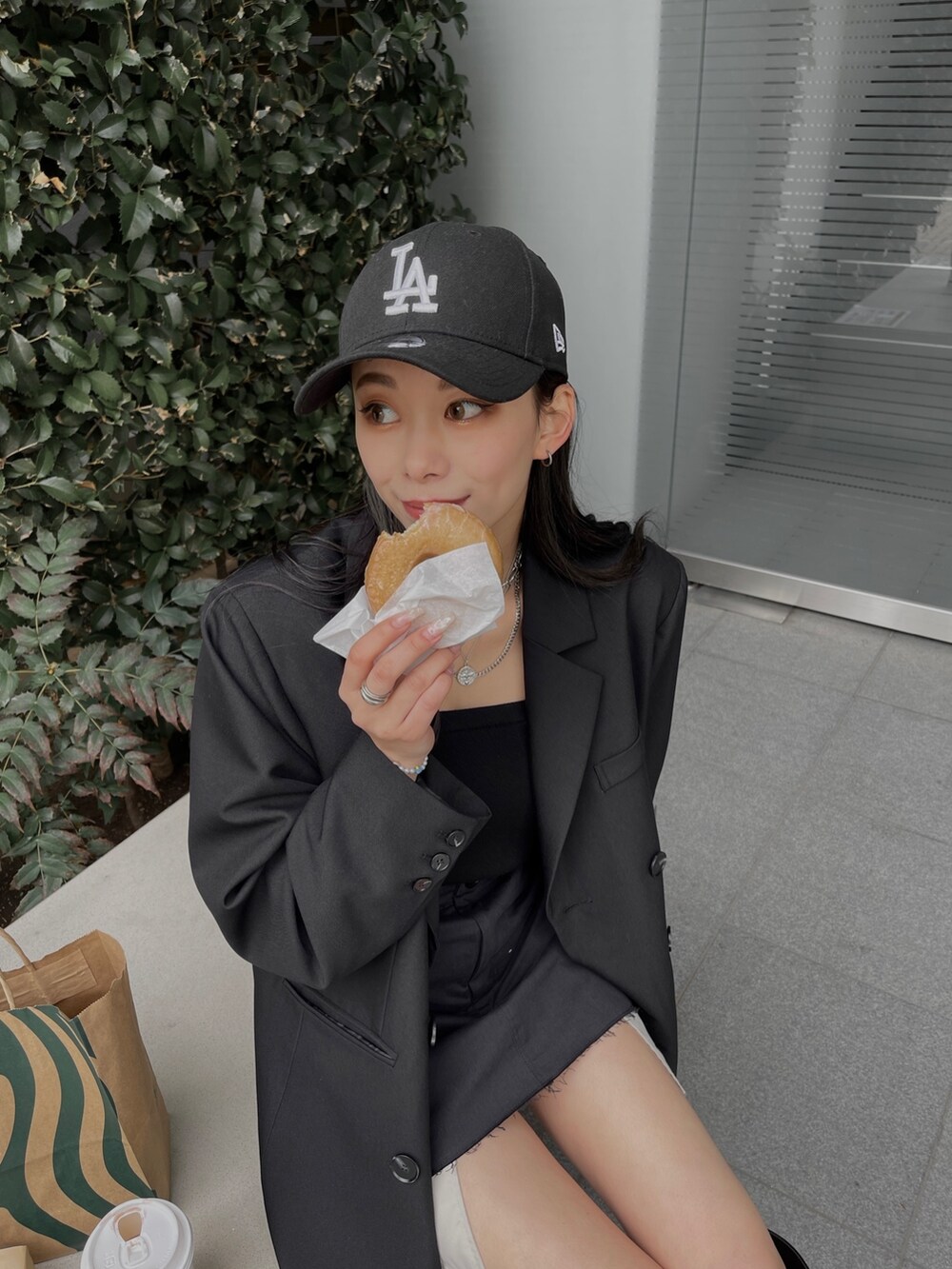 ブラック系のテーラードジャケット、ブラック系のスカート、ブラック系のブーツを着用したレディースの冬コーディネートの2枚目の写真