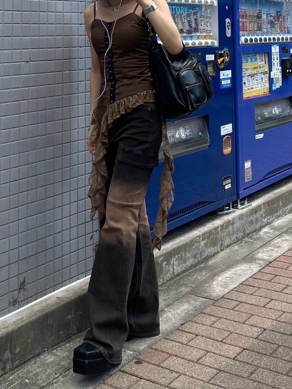 ブラウン系のキャミソール、ブラウン系のデニムパンツ、ブラック系のブーツを着用したレディースの夏コーディネートの4枚目の写真