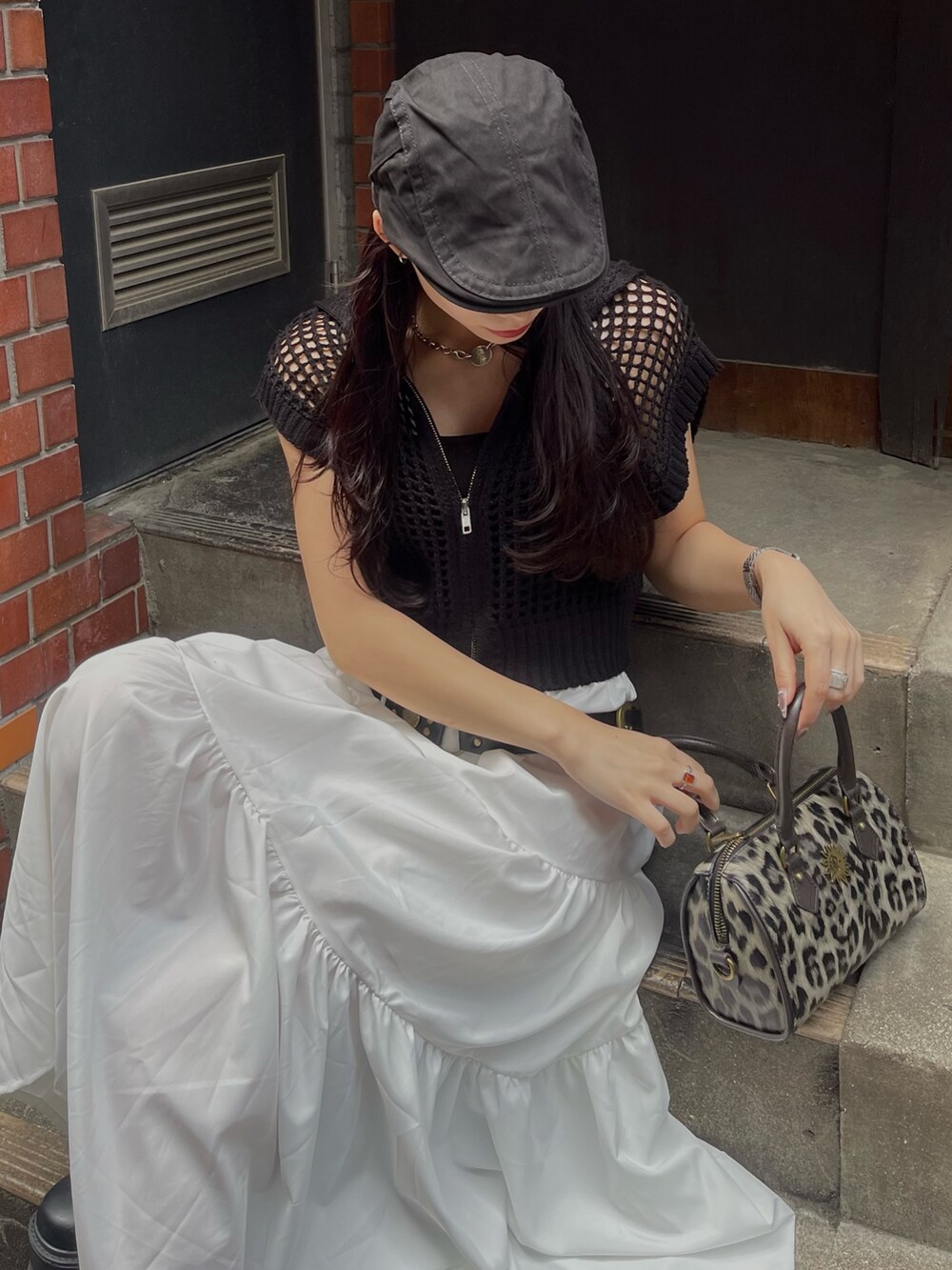 ブラック系のニット/セーター、その他のショルダーバッグ、ブラック系のブーツを着用したレディースの春コーディネートの5枚目の写真