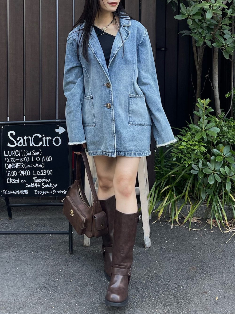 ブルー系のデニムジャケット、ブラック系のTシャツ/カットソー、ブラウン系のブーツを着用したレディースの夏コーディネートの2枚目の写真