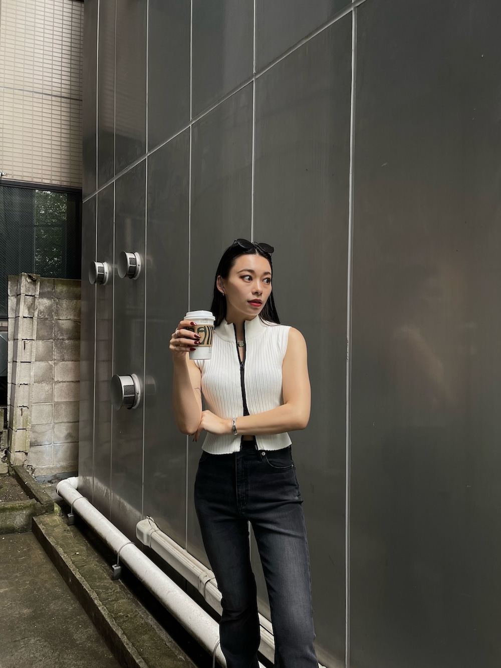 ホワイト系のタンクトップ、ブラック系のデニムパンツを着用したレディースの春コーディネートの3枚目の写真