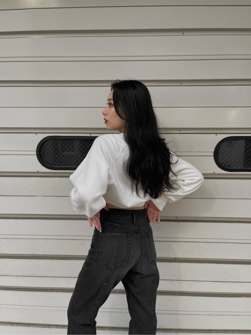 ブラック系のブルゾン、ブラック系のデニムパンツ、ホワイト系のスウェットを着用したレディースの秋コーディネートの6枚目の写真
