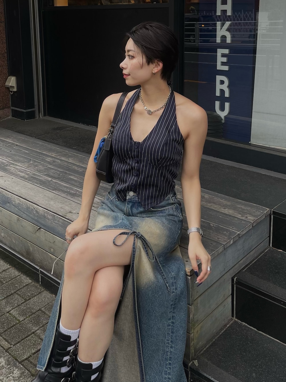 ブルー系のデニムスカート、ブラック系のブーツを着用したレディースの夏コーディネートの4枚目の写真