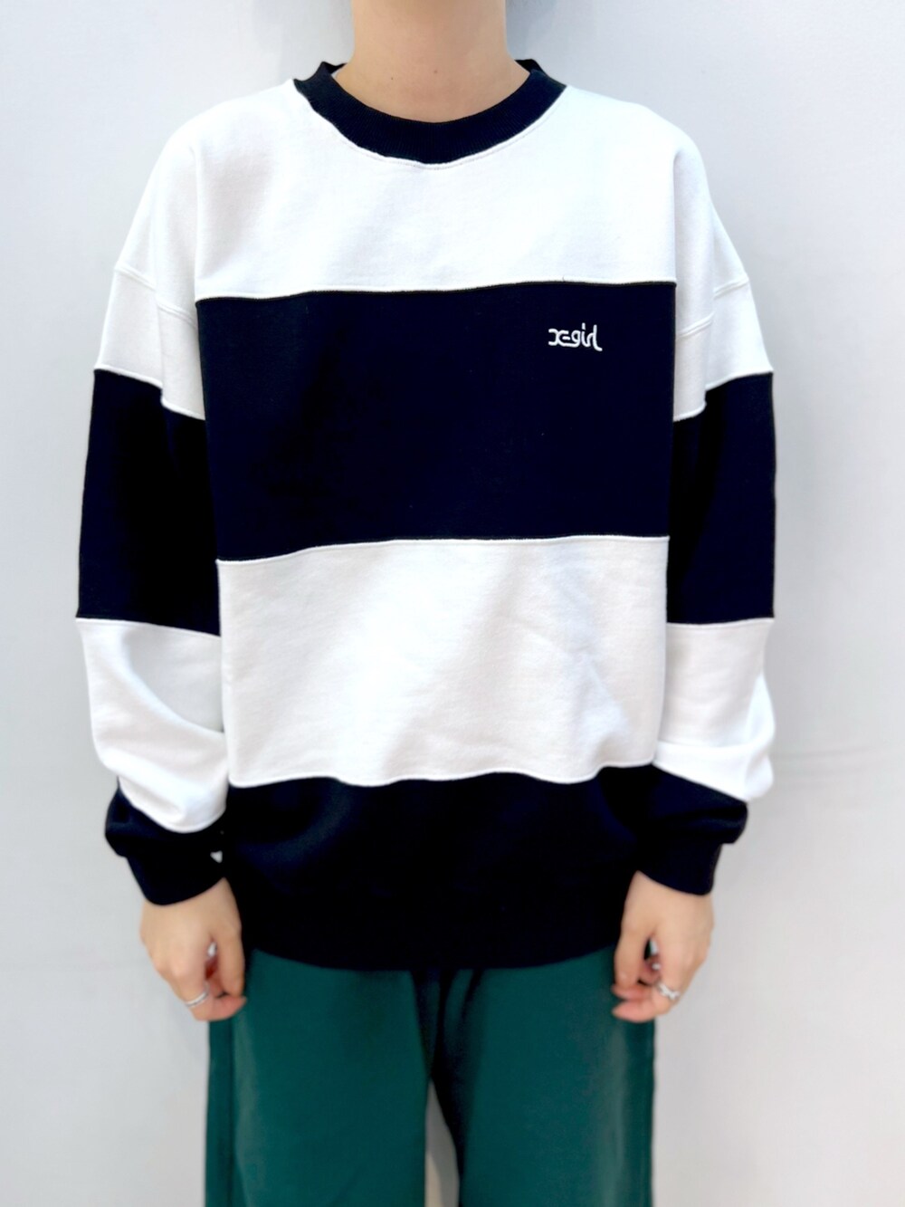 グリーン系のスウェットパンツ、ホワイト系のスウェット、ブラック系のキャップを着用したレディースの秋コーディネートの3枚目の写真