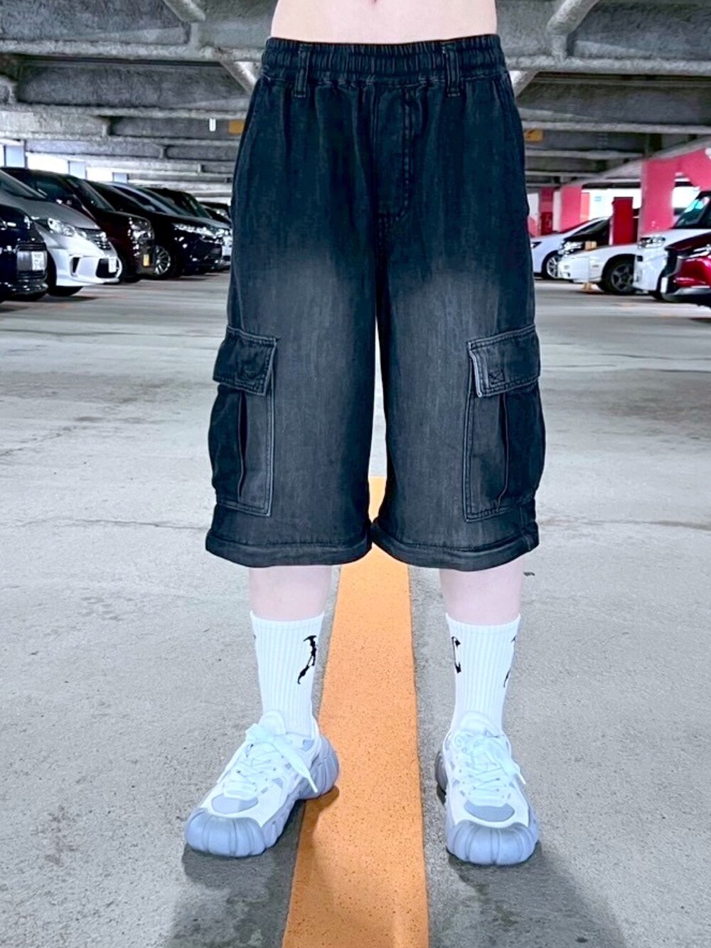 ブラック系のデニムパンツ、ブルー系のポロシャツ、ホワイト系のソックス/靴下を着用したレディースの春コーディネートの4枚目の写真