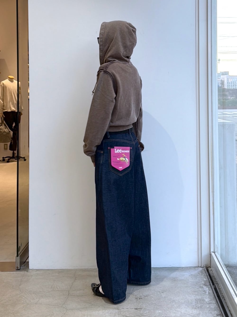ブルー系のデニムパンツ、ブラウン系のパーカー、ブラック系のベルトを着用したレディースの夏コーディネートの2枚目の写真