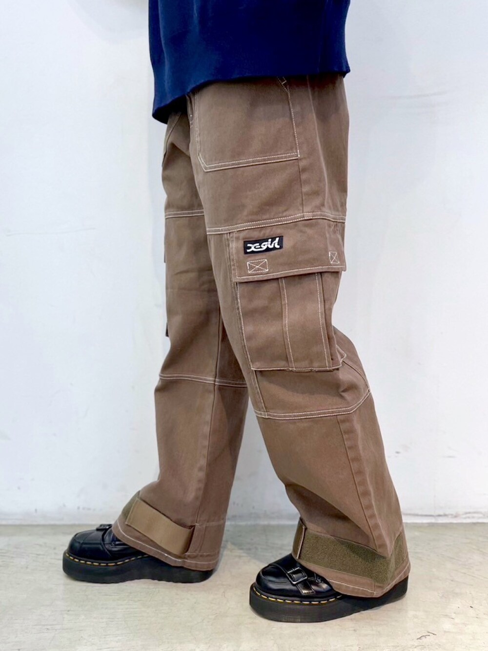 グリーン系のカーゴパンツ、ブルー系のニット/セーター、ブラック系のキャップを着用したレディースの秋コーディネートの5枚目の写真