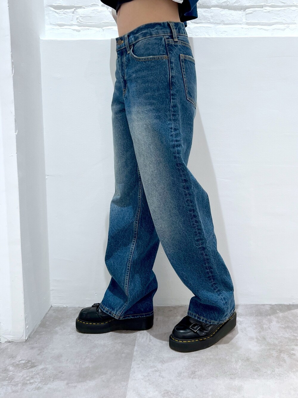 ブルー系のデニムパンツ、ブラック系のハンドバッグ、ブルー系のTシャツ/カットソーを着用したレディースの春コーディネートの5枚目の写真