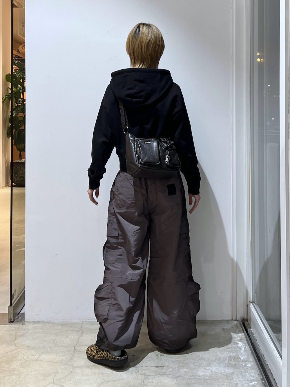 ブラック系のカーゴパンツ、ブラック系のショルダーバッグ、ブラック系のパーカーを着用したレディースの冬コーディネートの2枚目の写真