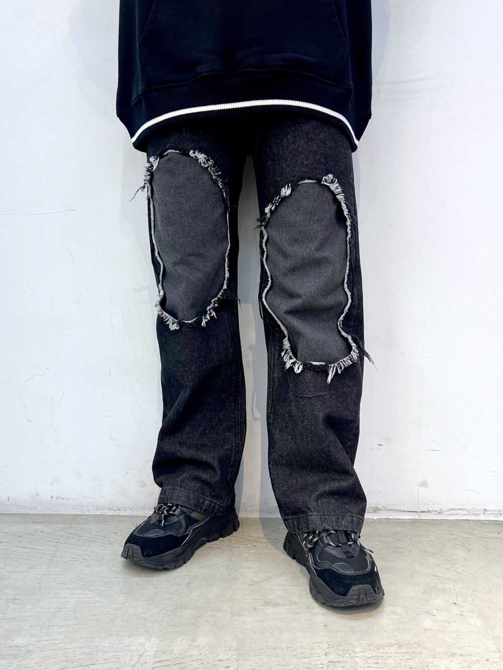 ブラック系のデニムパンツ、ブラック系のスウェット、ブルー系のハットを着用したレディースの冬コーディネートの4枚目の写真