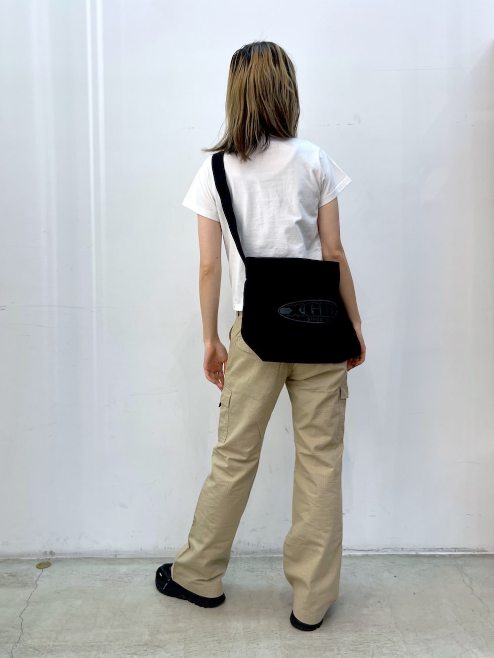 ベージュ系のその他パンツ、ブラック系のショルダーバッグ、ホワイト系のTシャツ/カットソーを着用したレディースの夏コーディネートの2枚目の写真