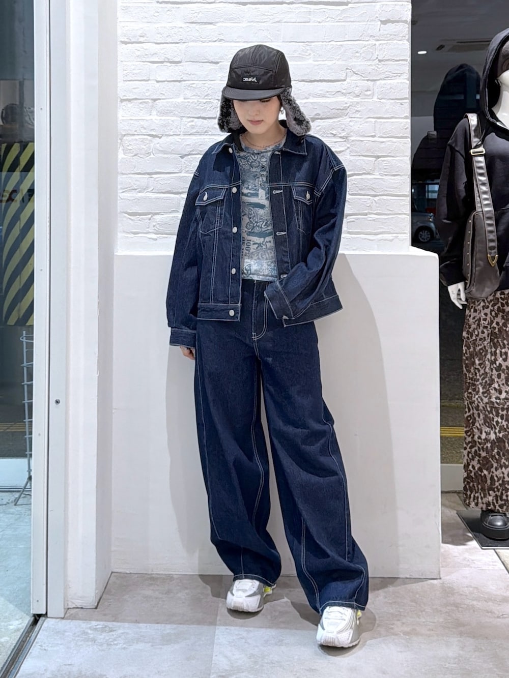 ブルー系のデニムパンツ、ブルー系のデニムジャケット、ブラック系のキャップを着用したレディースの秋コーディネートの2枚目の写真