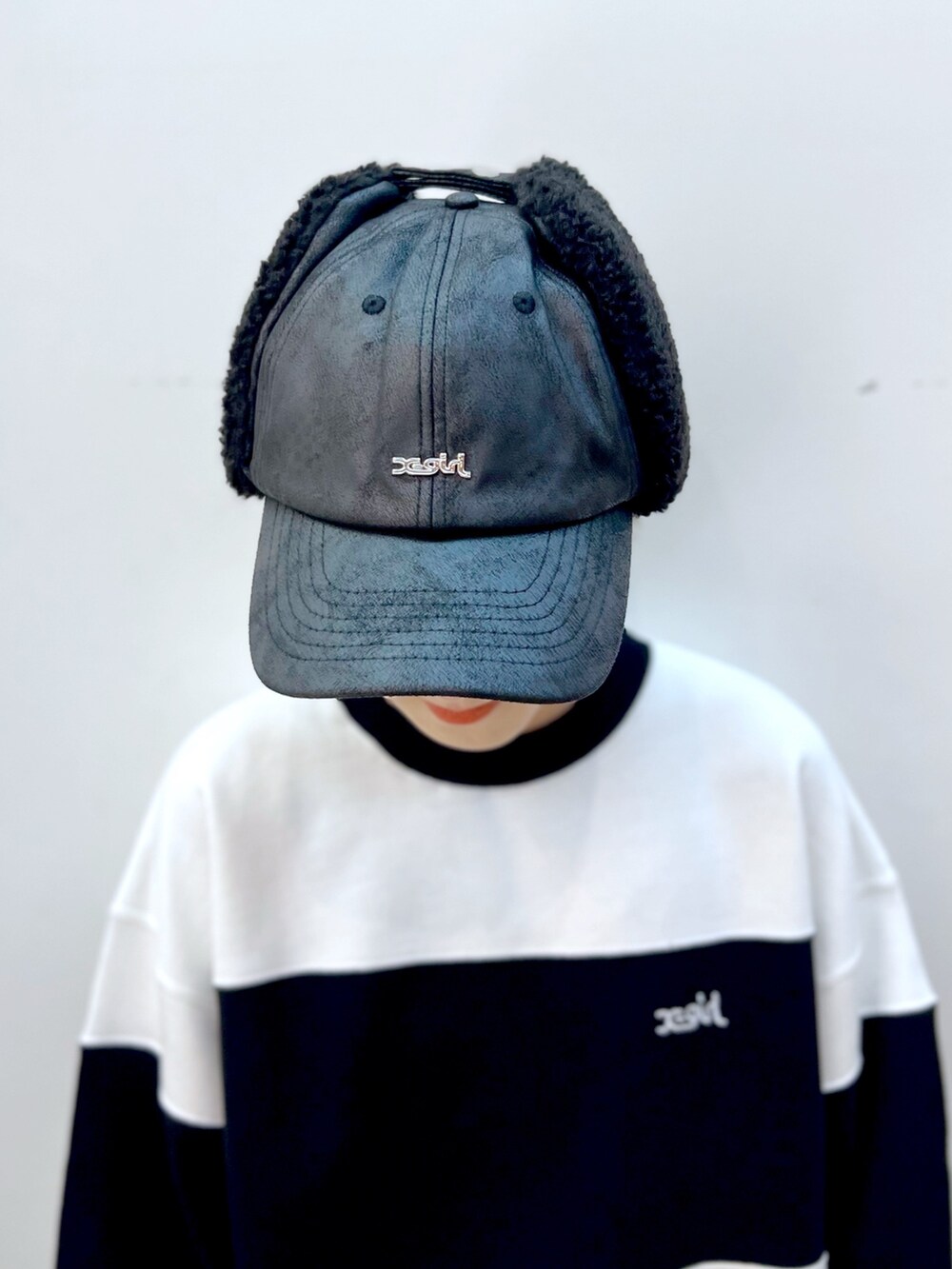 グリーン系のスウェットパンツ、ホワイト系のスウェット、ブラック系のキャップを着用したレディースの秋コーディネートの6枚目の写真