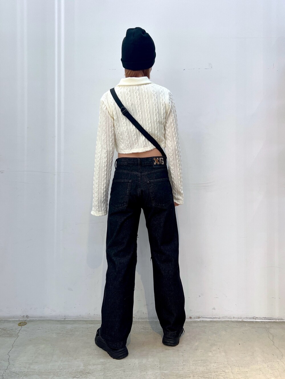 ブラック系のデニムパンツ、グリーン系のショルダーバッグ、ホワイト系のシャツ/ブラウスを着用したレディースの春コーディネートの2枚目の写真