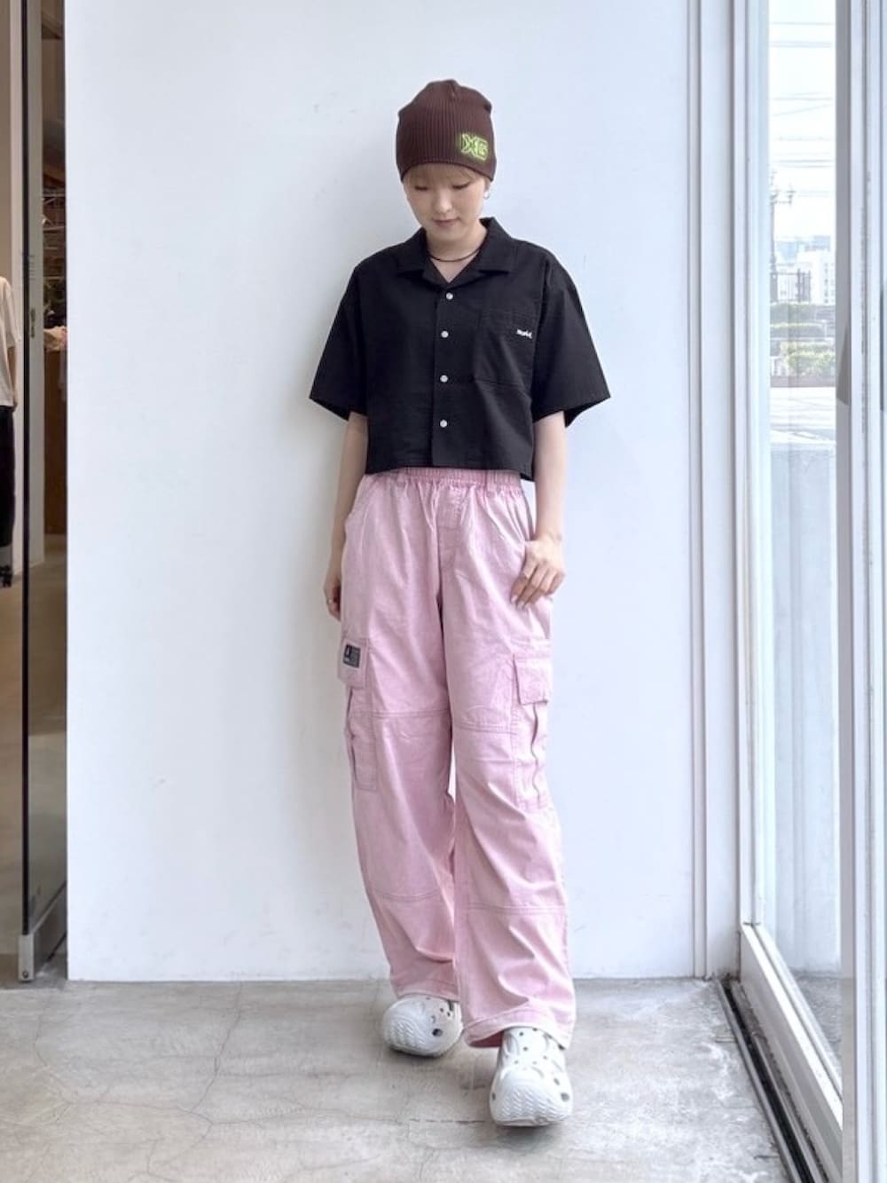 ピンク系のカーゴパンツ、ブラック系のシャツ/ブラウス、ブラウン系のニットキャップ/ビーニーを着用したレディースの夏コーディネートの2枚目の写真